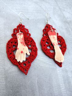 These somewhat asymmetrical doily earrings feature a resin arm and leg charm on a rhodium-plated fish hook earring, with a handmade doily in red crochet thread, made by me. The doily has been starched to keep its shape, and to stay stable. The charms measure 1.75" (arm) and 2.0" (leg) long, by approximately 0.5" wide, and the doilies measure approximately 2.0" wide x 3.0" long. Feel free to reach out if you have any questions! Red Crochet Jewelry As A Gift, Red Crochet Jewelry Gift, Red Crochet Jewelry For Gift, Gift Red Crochet Jewelry, Doily Earrings, Red Crochet, Crochet Thread, Fish Hook Earrings, Thread Crochet