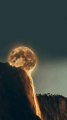 a full moon rising over the top of a mountain