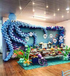 an under the sea themed birthday party with balloons and decorations on the wall, along with fish