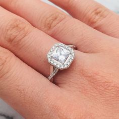 a woman's hand with a diamond ring on her finger and an engagement band