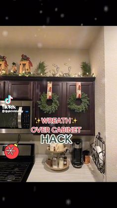 a kitchen with christmas wreaths on the cabinets and over the oven rack above it