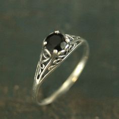 Filigree Engagement Ring Cinderella Onyx Ring Antique Style Ring Vintage Style Ring Scrollwork Solitaire 5mm Black Stone Ring Blazer Arts"If you keep on believing, the dream that you wish will come true"Cinderella sparks memories of glass slippers, fairy god mothers, and dancing at midnight. This is her ring...dainty, intricate and as stunning as can be! A detailed filigree setting securely holds a 5mm Facetted Onyx. It is surrounded by intricate vining filigree. The top of the sterling silver r Black Crystal Ring, Antique Style Rings, Black Stone Ring, Black Engagement Ring, Filigree Engagement Ring, Handmade Engagement Rings, Vintage Style Rings, Hot Jewelry, Color Cafe