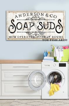 a washer and dryer are in front of a sign that says soap suds