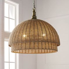 a light fixture hanging from a ceiling in a room with white walls and wooden flooring