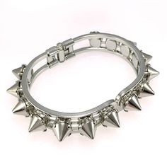 This stunning cuff is made of individually handset silver spikes in pronged settings, arranged around a hinge closure cuff. The oval shape fits comfortably on most wrists and is perfect for stacking or wearing solo. With its edgy design, this cuff will add a touch of rebellious glamour to any outfit. Whether you're dressing up for a night out or adding a little edge to your everyday look, the Helios Cuff is the perfect accessory for any occasion. DETAILS Bracelet Diameter: 7” Made to order. Plea Studs And Spikes, Edgy Elegance, Metal Spikes, Edgy Design, Body Lotions, Silver Cuff Bracelet, Italian Charm Bracelet, Bracelet Sizes, Hair Jewelry