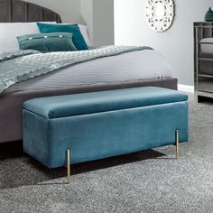 a large bed with a blue footstool sitting on top of it's side