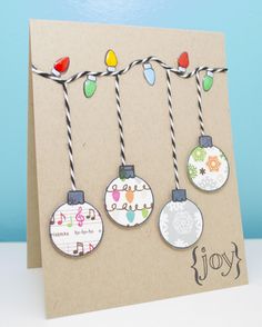 a handmade christmas card with ornaments hanging from it's string and the words joy