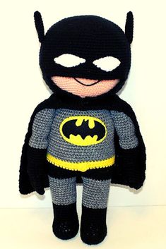 a crocheted batman doll sitting on top of a white table next to a wall