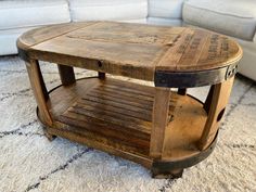 a wooden coffee table sitting on top of a rug next to a white couch in a living room