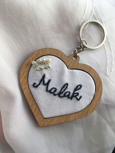 a wooden heart shaped keychain with the word melak on it