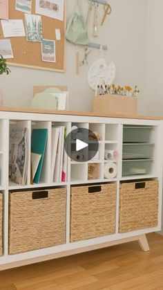 a white shelf with baskets and pictures on it