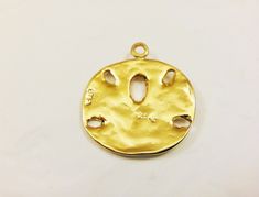 This vermeil sand dollar charm measures about 18mm in diameter. It is perfect for bracelet, necklace and earrings. It is 18k gold plated over 925 sterling silver (vermeil), shiny gold. 925 stamped in the back. 1 pc. silver version: Listing: http://www.etsy.com/listing/114478741/925-sterling-silver-oxidized-sand-dollar matte vermeil version: Listing: http://www.etsy.com/listing/150706144/vermeil18k-gold-over-925-sterling-silver For the larger quantity convo us. Thanks for stopping by! Tarnish Resistant Gold Beach Jewelry, Tarnish Resistant Gold Jewelry For Beach, Gold Round Beach Jewelry, Gold Round Jewelry For Beach, Gold Round Jewelry For The Beach, Gold Medallion Charms With Coin Pendant, Gold Coin Pendant Charms, Gold Pendant Jewelry With Starfish Charm, Gold Round Pendant Jewelry For The Beach