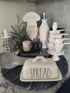 a table topped with dishes and cups filled with food