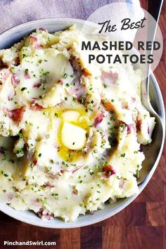 a bowl filled with mashed potatoes covered in butter and seasoning next to a fork