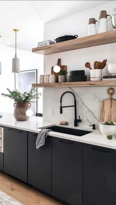 a kitchen with black cabinets and white counter tops is featured in the instagram post