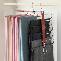 several different colored pants hanging on a rack