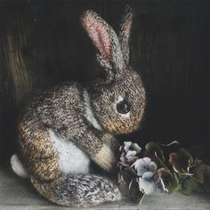 a stuffed rabbit sitting next to some flowers