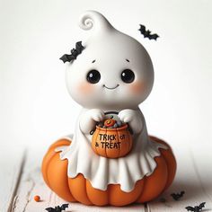 a little white cat sitting on top of a pumpkin with a trick or treat in it's mouth