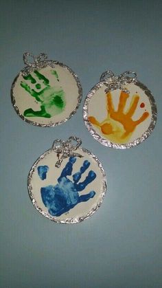 three handprinted pendants are shown on a table