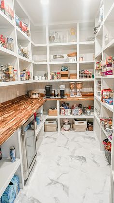 an organized pantry with wooden shelves and white marble flooring is pictured in this image