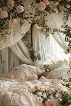 an unmade bed with white sheets and pink flowers on the headboard, along with sheer curtains