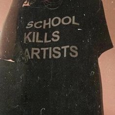 a person holding a cell phone up to their ear and wearing a t - shirt that says school kills artists