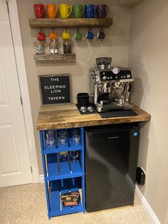 a small kitchen with a coffee maker and blue cart in the corner next to it