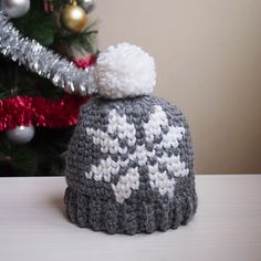 a knitted hat sitting next to a christmas tree