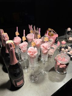 a table topped with lots of pink desserts and bottles of champagne on top of it