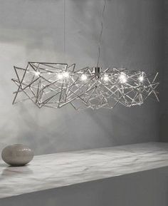 a modern light fixture hanging over a table