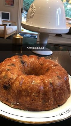 a bundt cake sitting on top of a white plate next to a glass table