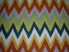 an orange, green, yellow and blue zigzag pattern on a blanket