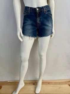 "Vintage Women's 90's Levi's 517, High Waisted, Cut Off's, Denim, Shorts (S) 669 These Ladies Shorts come in a medium blue colored wash cotton and have three front pockets, two back pockets and are high waisted with belt loops, front button closure with signature Levi's red tab logo and fringe front. 100% Cotton Made in Guatemala *These shorts are in excellent condition. Size: (S) Modern Day 4 (Tag Size: 5 jr M) Waist: 30\" Length: 12 1/2\" (unfolded) Hips: 34\" Rise: 10\" (front) 13\" (back) In Casual Dark Wash Shorts With Frayed Hem, Dark Wash Bottoms With Frayed Hem, Dark Wash Short Bottoms With Frayed Hem, Dark Wash Frayed Hem Shorts, Retro Denim Blue Bottoms With Frayed Hem, Retro Denim Bottoms With Built-in Shorts, Dark Wash Short Leg Jeans With Frayed Hem, Casual Dark Wash Bottoms With Frayed Hem, Medium Wash Short Leg Bottoms With Frayed Hem