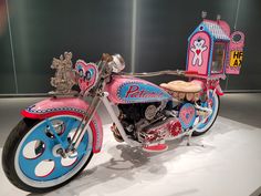 a pink and blue toy motorcycle on display