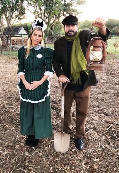 the man and woman are dressed up as scarecrows, one is holding a shovel