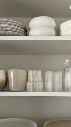 white dishes and bowls on shelves in a room