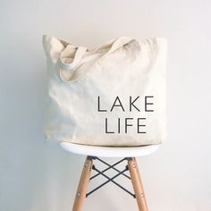 Pack your lake essentials in style with the Lake Life carry all bag. Made with durable canvas, this bag is perfect for all your day trip needs. Say goodbye to multiple bags and hello to convenience and function. Ready for some serious lake living? Let's go! Gifts For The Lake, Casual Canvas Tote Bag For Outdoor Activities, Cotton Tote Bag For Outdoor Activities, Cotton Tote Bags For Outdoor Activities, Rectangular Cotton Canvas Bag For Outdoor Activities, Large Capacity Cotton Bags For Weekend Trips, Eco-friendly Canvas Bag For Weekend Trips, Canvas Tote Bags For Outdoor Activities, Lake Day Essentials