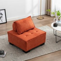 an orange chair sitting on top of a rug in a living room