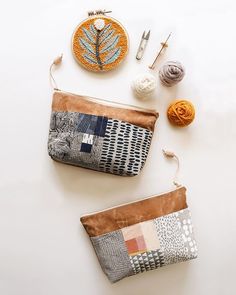 two purses sitting next to each other on top of a white table with crochet and knitting supplies