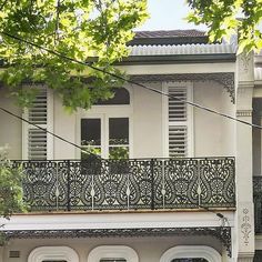 an ornate balcony and balconies on the front of a white two story house