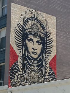 a mural on the side of a building depicting a woman wearing a headdress