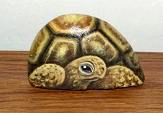 a small turtle figurine sitting on top of a wooden table