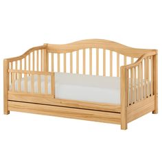 a wooden crib with white sheets on the bottom and side rails, in light wood