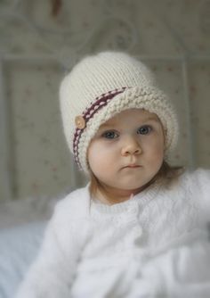 a small child wearing a white knitted hat