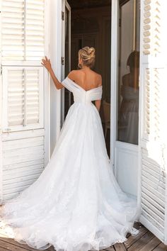 a woman in a wedding dress is standing outside the door