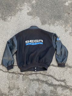 Vintage Sega Jacket  - Letterman style varsity jacket  - Rare limited release promo  - Collector's item  - Leather sleeves  - Wool body  - R Zone sleeve embroidery  - Sega Sports back logo - Embroidered spell out  Size: XL fits L Great vintage condition small tear on left cuff  No stains Sporty Embroidered Graphics Outerwear For Streetwear, Sporty Embroidered Outerwear For Streetwear, Sporty Streetwear Outerwear With Embroidered Graphics, Retro Crew Neck Varsity Jacket For Streetwear, Retro Crew Neck Outerwear For College, Black Varsity Jacket With Embroidered Graphics For Streetwear, Sporty Varsity Jacket With Embroidered Graphics For Streetwear, Retro Outerwear With Embroidered Logo For Streetwear, Sporty Embroidered Varsity Jacket For Streetwear