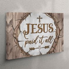 a wooden sign with the words jesus paid it all written in brown on top of it