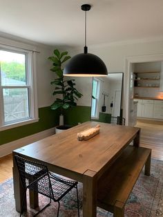 a dining room table and bench in front of two windows