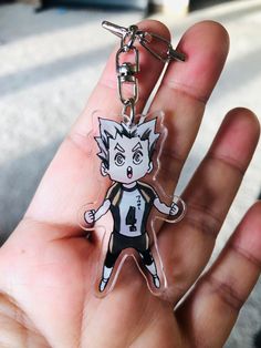 a hand holding a key chain with a cartoon character on it