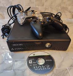 two video game controllers sitting on top of a table next to a cd